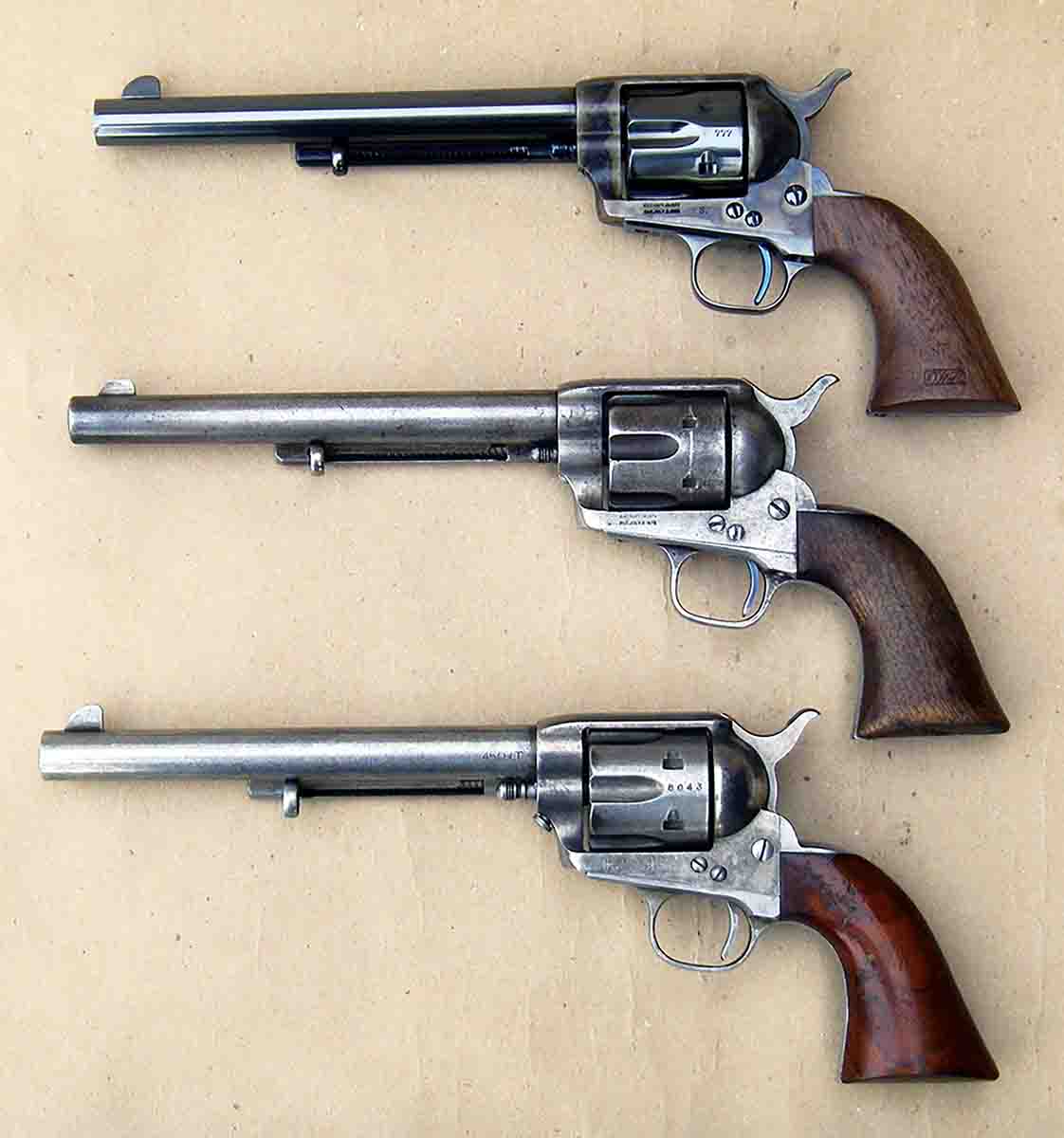 Top to bottom: An original “US” marked Colt Single Action Army manufactured in 1873 (restored), a heavily used Colt Single Action Army manufactured in 1876 and a Uberti/Cimarron Model P Original Finish.